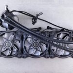 Top view of a triple radiator cooling system with fans for computer hardware in a minimalist gray setting.